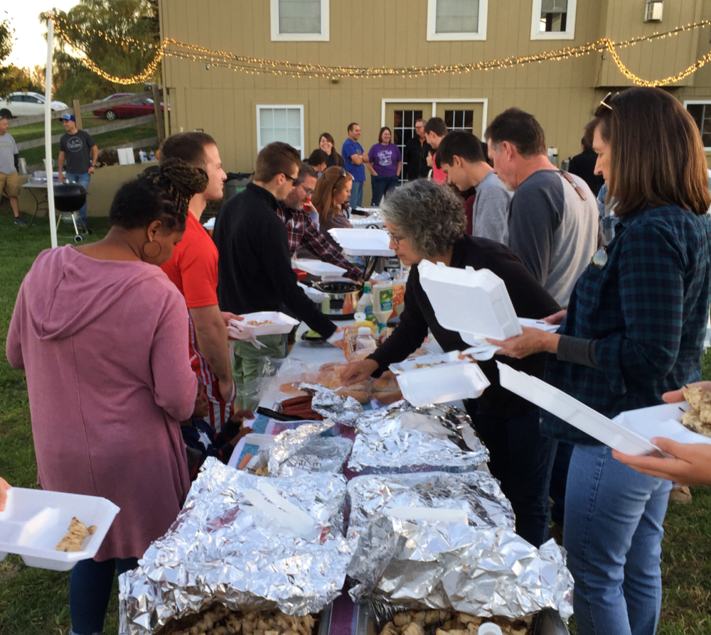 Members of Rock Hill filling their plates with food at an outdoor potluck